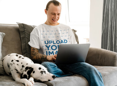 Round-Neck Tee Mockup of a Man with an Arm Tattoo Sitting on a Couch with His Dog m25411 r-el2