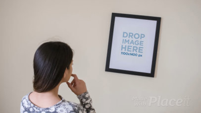 Young Woman Adjusting a Framed Art Print on her White Wall Video