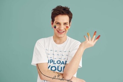 T-Shirt Mockup Featuring a Cheerful Tattooed Man Painted by Multi-Colored Makeup