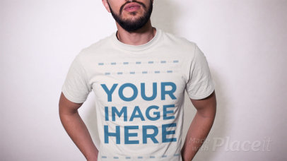 Trendy Guy With a Beard Wearing a T-Shirt and a Trucker Hat Against a White Wall a13473