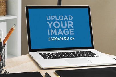 Mockup of a MacBook Placed on a Graphic Designer's Desk