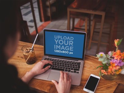 Over the Shoulder Shot of a Woman Working with a MacBook Pro Mockup
