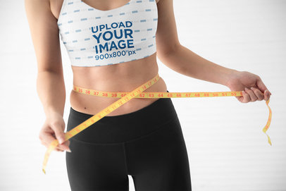 Sports Bra Mockup Featuring a Woman Measuring Her Waist