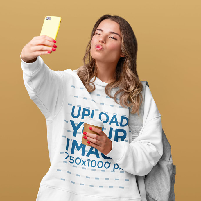 Hoodie Mockup Featuring a Woman Taking a Selfie and Holding a Cup of Coffee