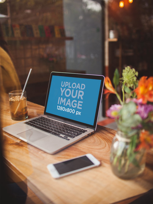 MacBook Mockup Lying Near a Phone and Some Flowers