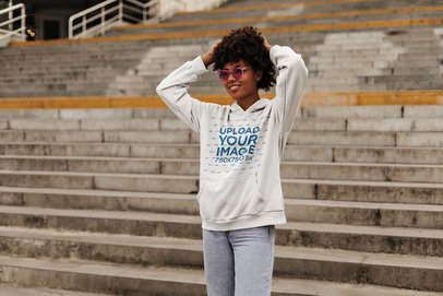 Hoodie Mockup Featuring a Happy Woman Posing Near Some Stairs