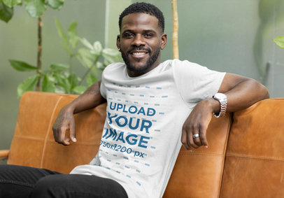 Bella Canvas Tee Mockup of a Man Posing on a Sofa