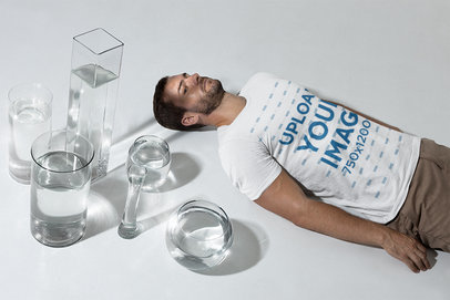 Mockup of a Man Wearing a Tee and Laying Next to Vases with Water m28424