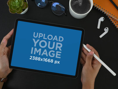 Mockup of a Woman Holding an iPad Featuring a Pair of Earphones m16140 r-el2