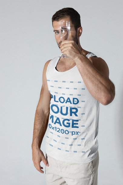 Mockup of a Man Wearing a Scoop Neck Tank Top and Holding a Wine Glass
