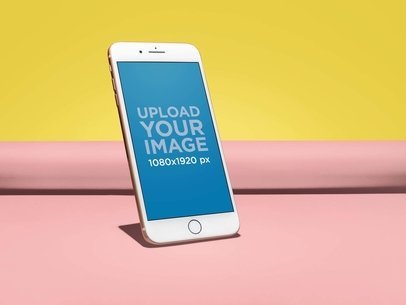 Gold iPhone 8 Mockup Standing Angled on a Rolled Up Paper