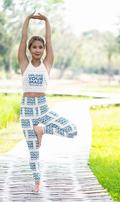 Crop Top and Leggings Mockup Featuring a Smiling Woman Doing Yoga Outdoors