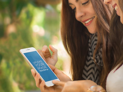 Young Woman Holding White iPhone 6 With Friend Mockup