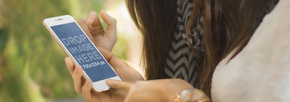 Mockup of Two Women Using an iPhone 6 in Portrait Position Outdoors