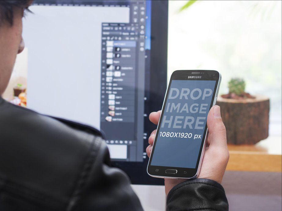 Mockup Of a Designer Using His Samsung S5 at The Office