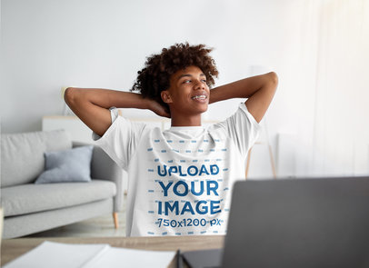 T-Shirt Mockup Featuring a Teenager Boy Relaxing in Front of a Laptop
