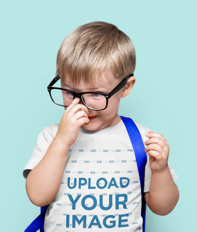 T-Shirt Mockup Featuring a Little Boy Adjusting His Glasses