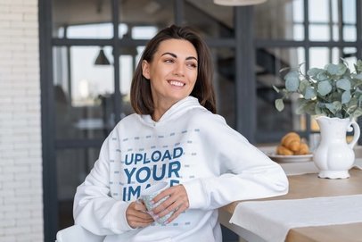 Hoodie Mockup of a Happy Woman Posing in Her Dining Room