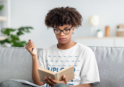T-Shirt Mockup Featuring a Teen Boy Reading a Book