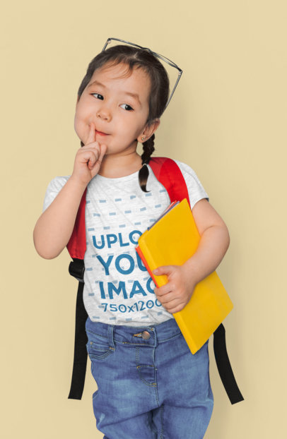 Heathered T-Shirt Mockup Featuring a Little Girl Holding a Yellow Notebook
