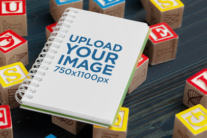 Mockup of a Notebook Placed Over Alphabet Blocks