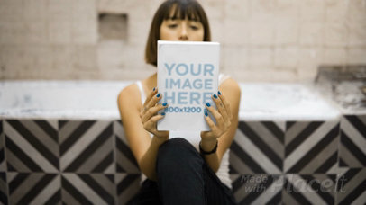 Trendy Woman Taking a Look at a Book Video While Sitting Down
