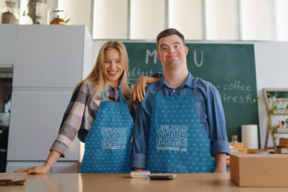 Mockup of a Man and a Woman Wearing Sublimated Aprons in a Restaurant