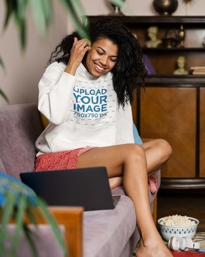 Pullover Hoodie Mockup of a Woman Sitting on Her Couch with a Laptop and Popcorn