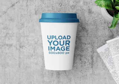 Mockup of a Paper Cup Placed by a Newspaper
