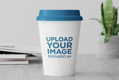 Mockup of a Paper Cup Placed on a Grey Table Featuring a Plant on the Background m29056 r-el2