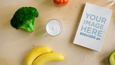 Video of a Book on a Wooden Table with Water Vegetables and Fruits Surrounding It