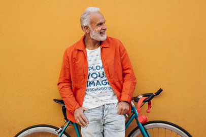T-Shirt Mockup Featuring a Happy Senior Man Leaning Against a Bike