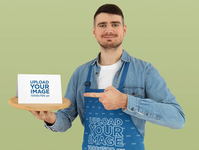 Apron Mockup Featuring a Smiling Man Holding a Flyer