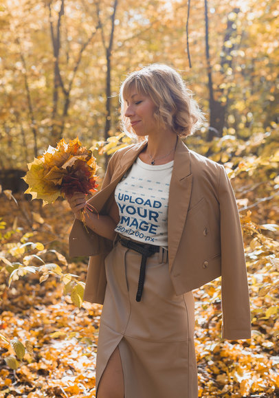 T-Shirt Mockup of a Happy Woman Holding Autumn Leaves