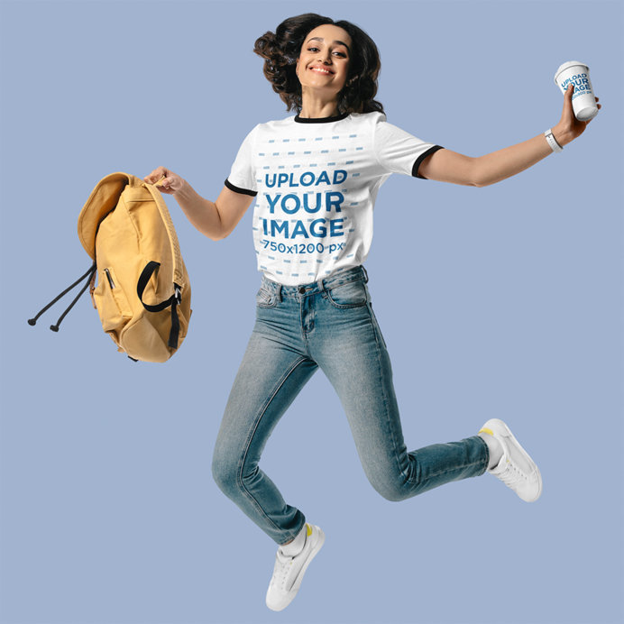 Ringer T-Shirt Mockup Featuring a Cheerful Woman Holding a Coffee Cup and Jumping in a Studio