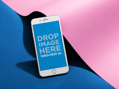 White iPhone 8+ Mockup Standing Angled Near a Paper