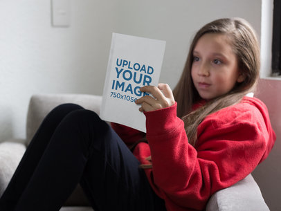 Little Girl Reading a Book Mockup on an Armchair