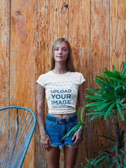 Blonde Woman Wearing a T-Shirt Mockup Against an Orange Wooden Wall