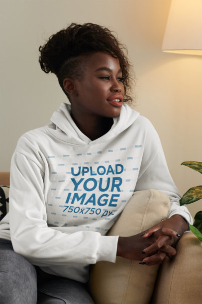 Hoodie Mockup Featuring a Happy Woman With Afro Hairstyle Sitting on a Couch