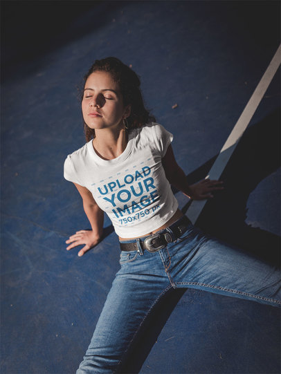 Woman Wearing a Crop Top Tshirt Mockup Sitting at a Blue Court at Night