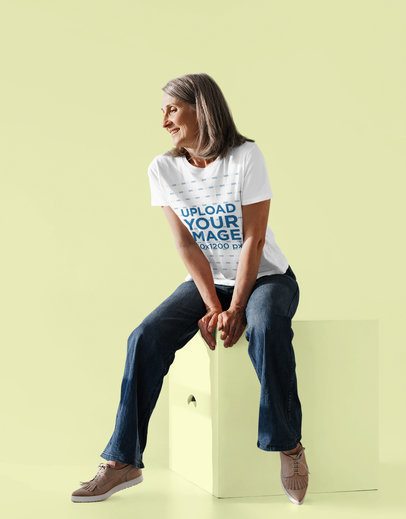 T-Shirt Mockup of a Happy Senior Woman Sitting on a Cube