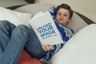Little Boy Reading a Book Mockup Lying on a Pillows