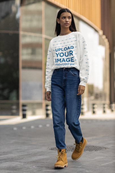 Mockup of a Woman Walking on a Street Wearing a Sweatshirt with Customizable Sleeves