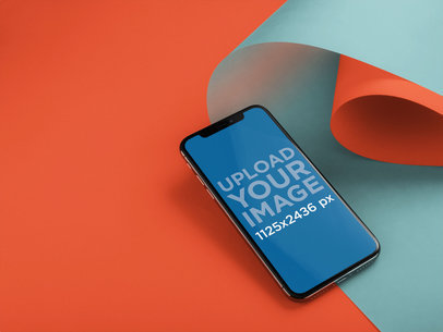 iPhone 11 Pro Mockup Lying Next to Rolled Up Pasteboards