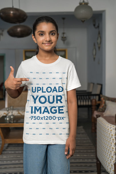 Mockup of a Smiley Girl Pointing at Her T-Shirt at Home