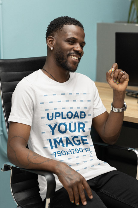 Rounded-Neck T-Shirt Mockup of a Bearded Man Sitting at an Office
