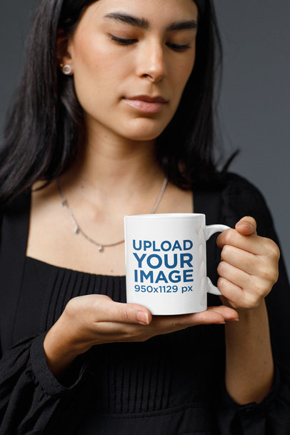 Mockup of a Woman Holding an 11 oz Coffee Mug in a Studio