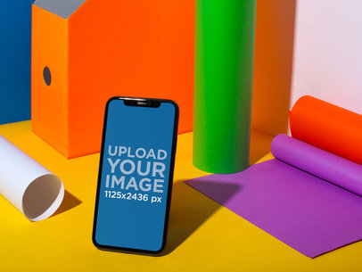 Black iPhone 11 Pro Mockup on a Surface with Colorful Things