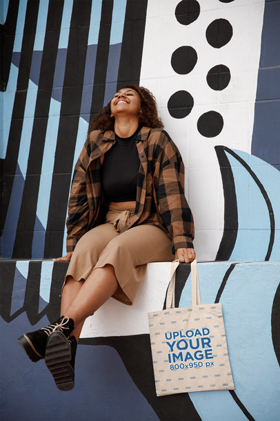 Mockup Featuring a Woman Laughing and Holding a Tote Bag 