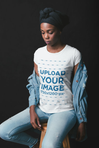 Mockup of a Woman Wearing a T-Shirt Sitting on a Stool at a Photo Studio 